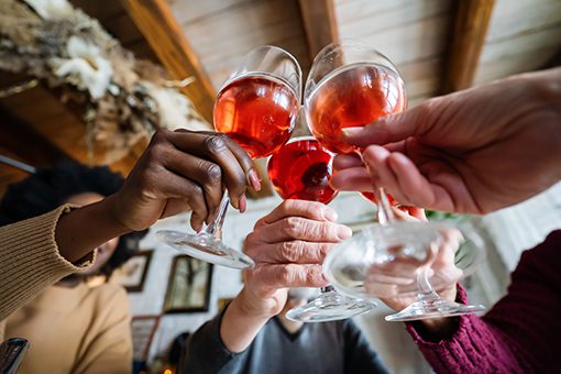 Happy multiethnic people toasting and having fun together at home. Holidays and celebration concept