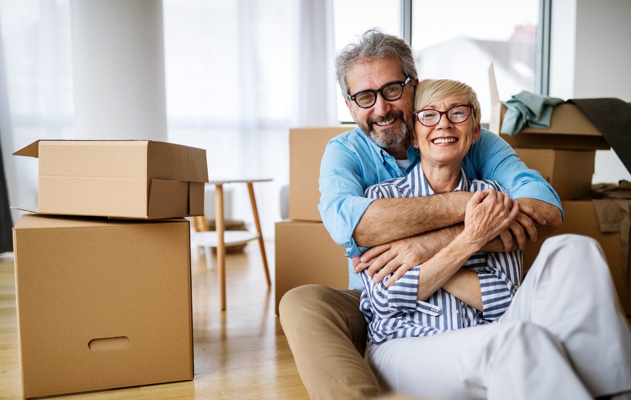 Smiling older couple moving into a new apartment.