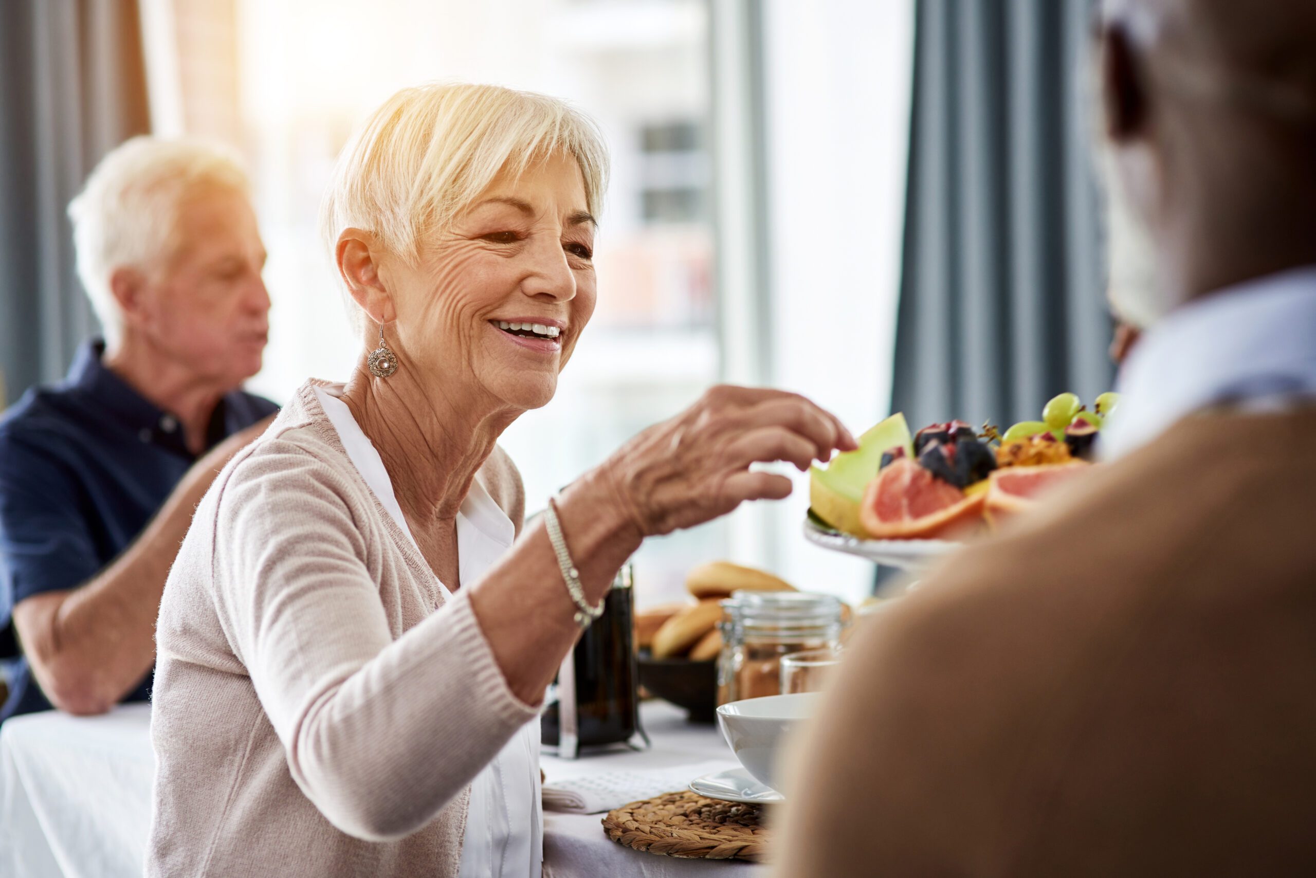 Let me try some of these Older adults eating a breakfast with fresh fruit together.