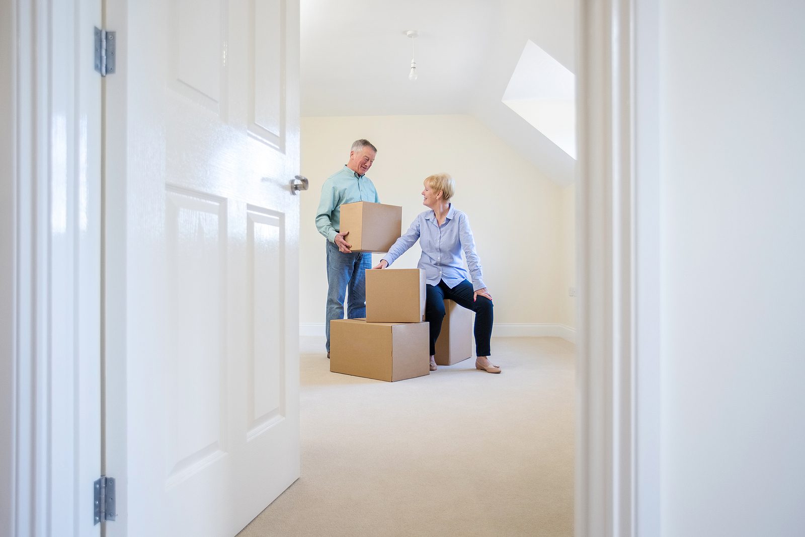 Senior couple packing boxes to downsize from family home