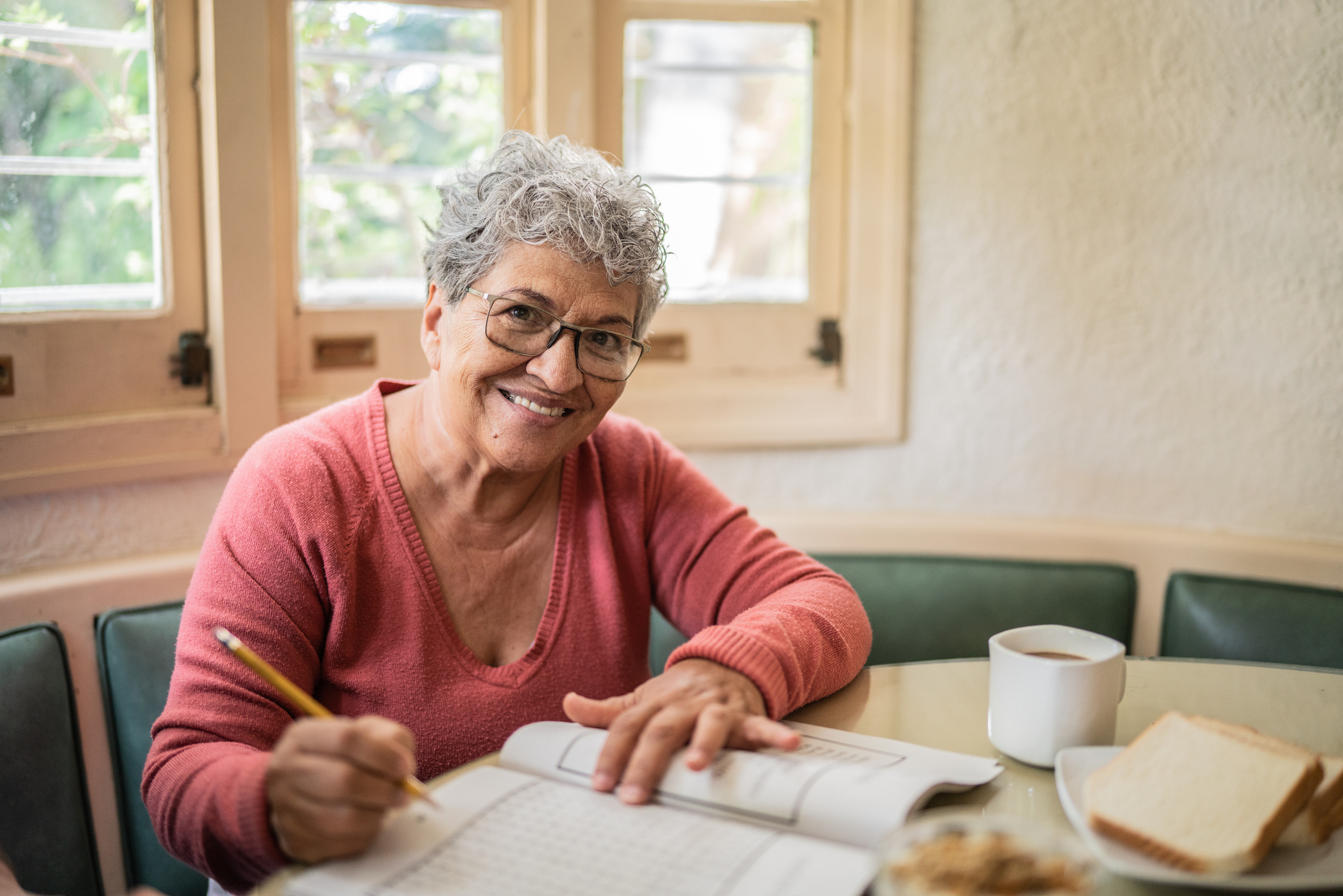 Senior adult woman at table with pencil and paper